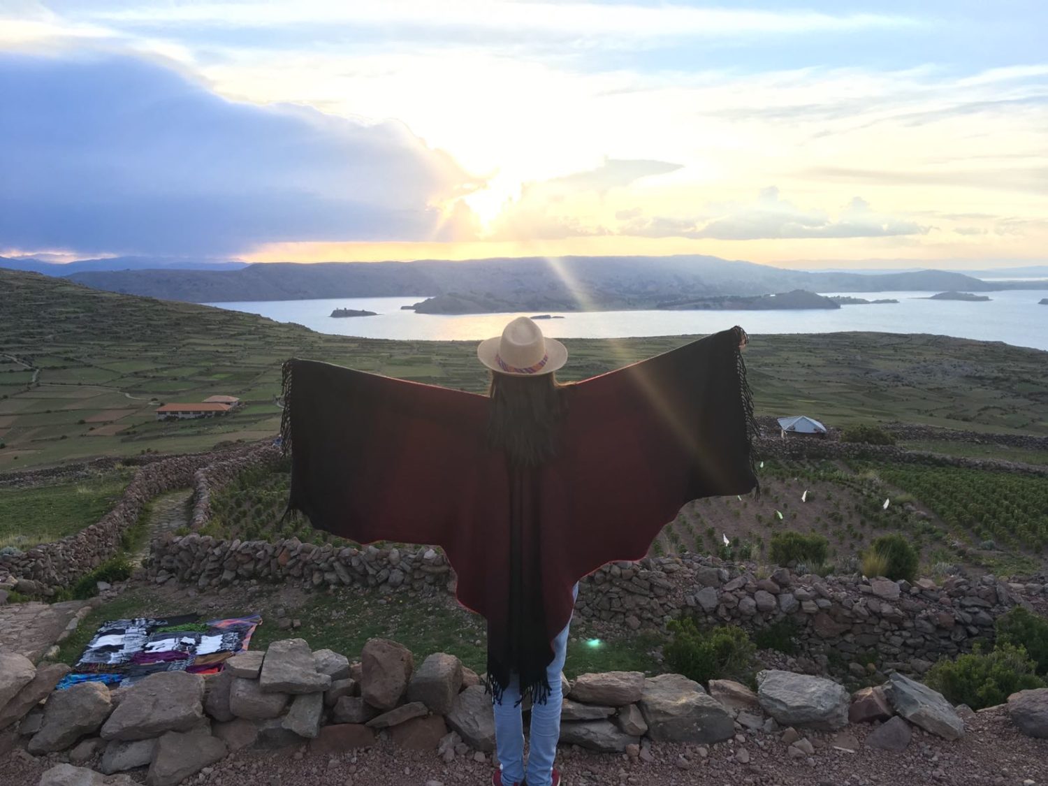 Eine Frau in peruanischer Kleidung steht auf einem Hügel