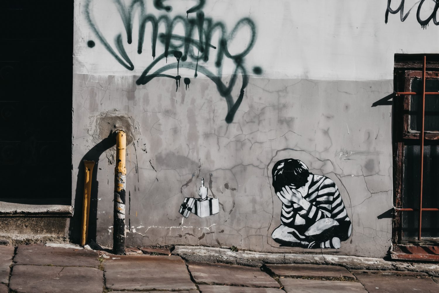 Wandgraffiti mit auf dem Boden sitzenden Kind