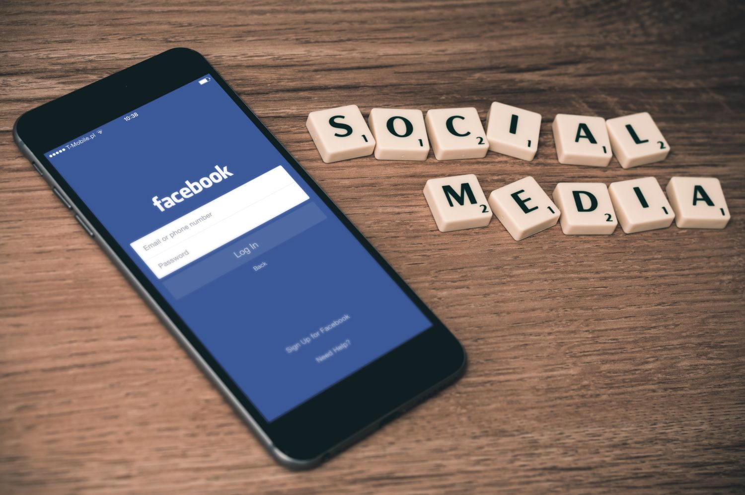 Smartphone mit Facebook-Logo auf dem Screen. Daneben die Worte "Social Media".