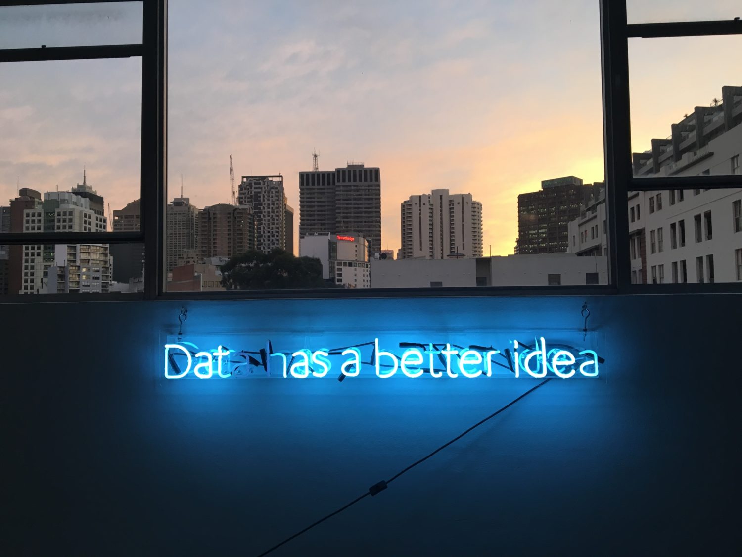 eine Wand mit der Aufschrift Data has a better idea mit Fenster, das einen Ausblick auf die Stadt hat
