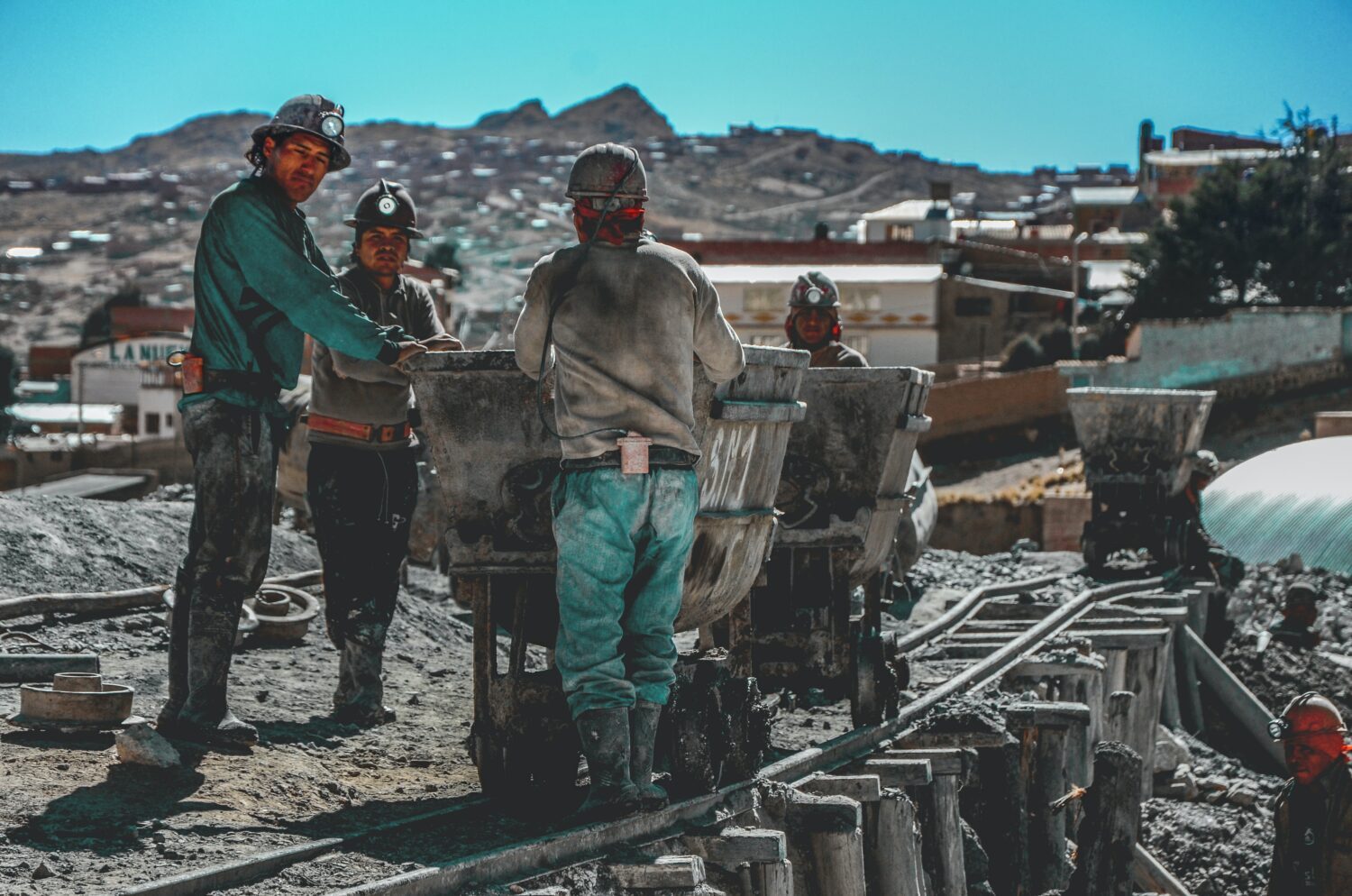 Bergarbeiter in der Stadt Potosí, neben einem Rollwagen