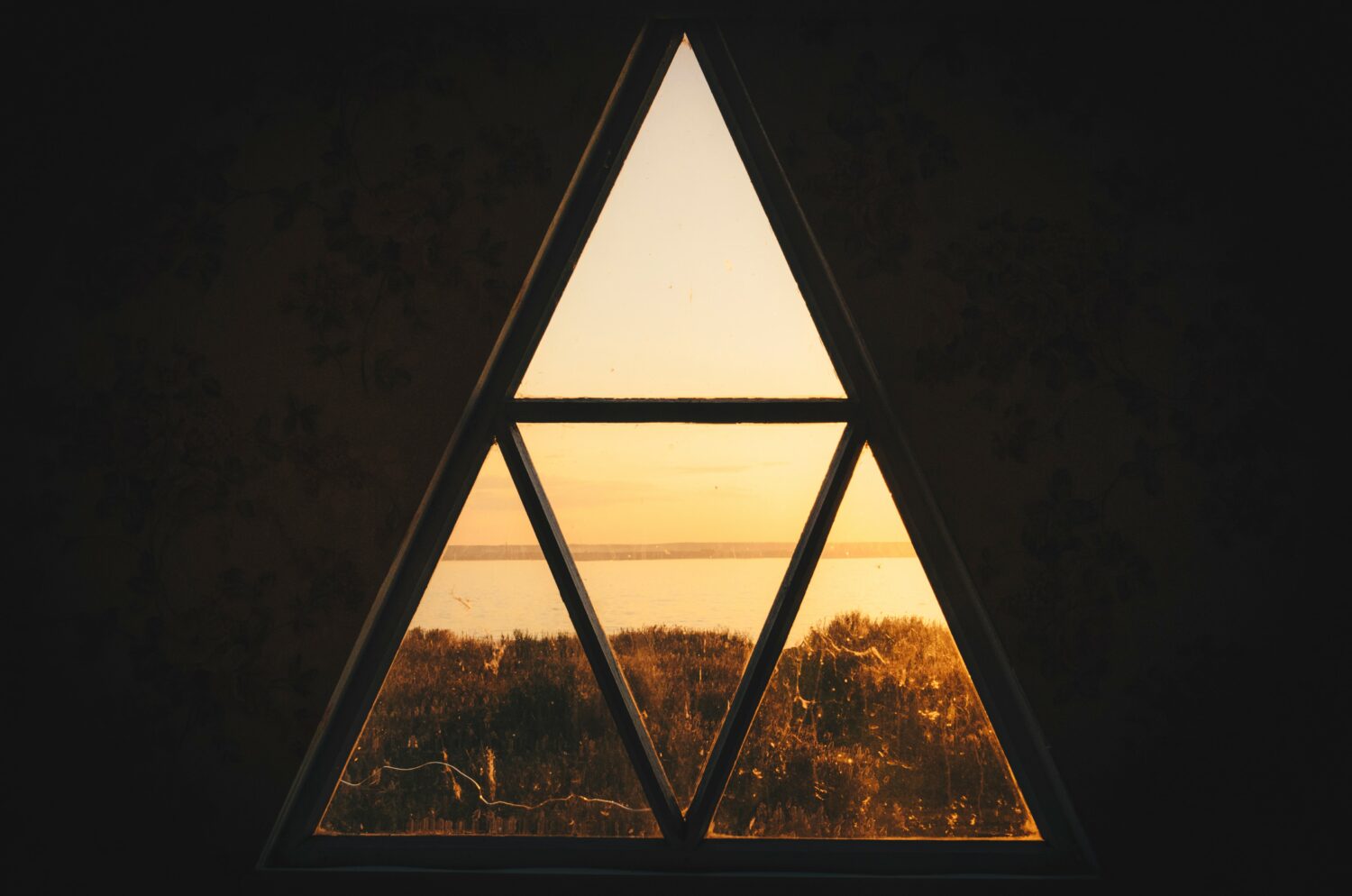 Goldener Himmel scheint durch ein dreieckiges Fenster, symbolisiert drei wichtigste Werte 