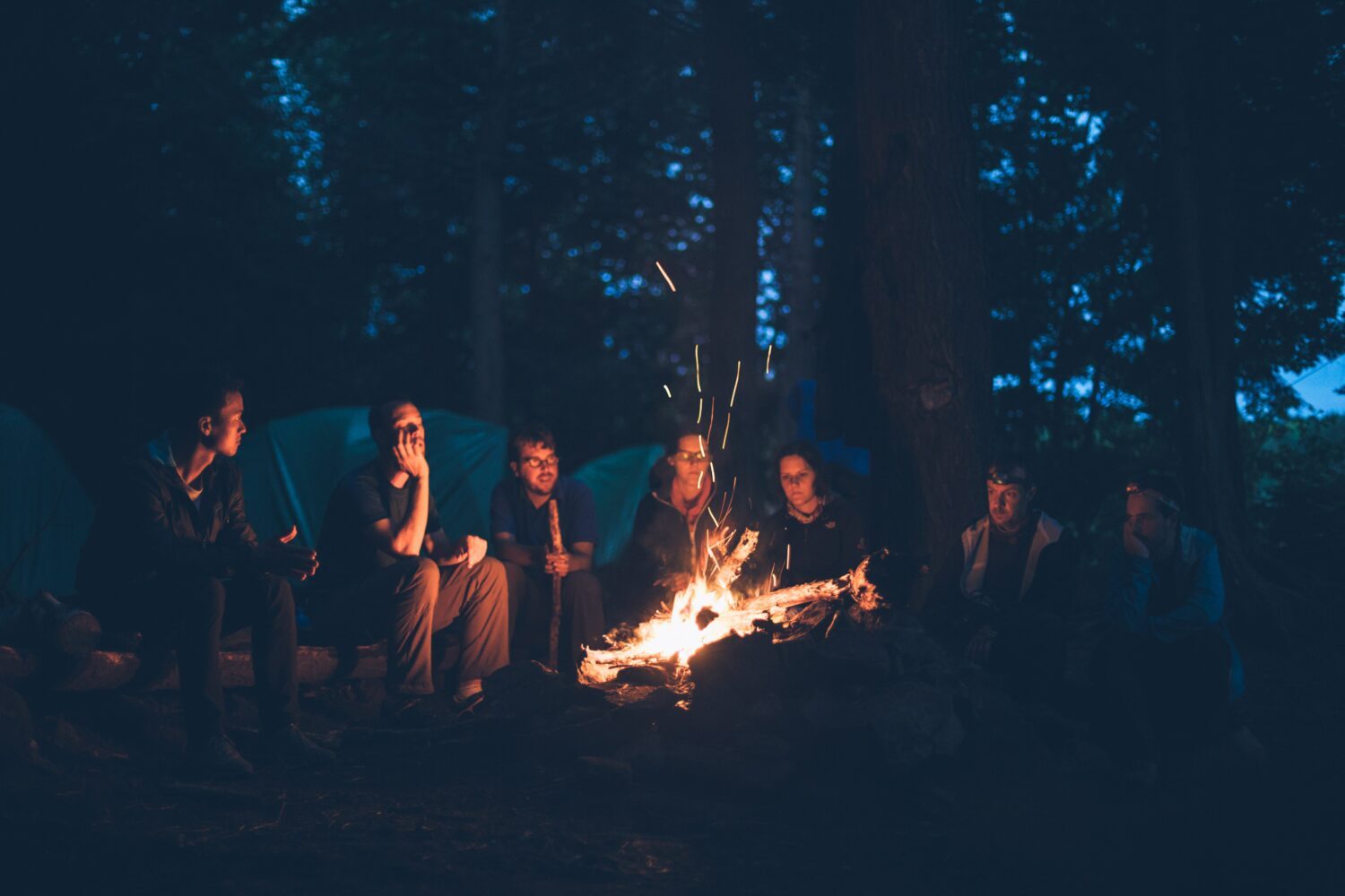 Corporate Campfire. Menschen sitzen um ein Lagerfeuer herum