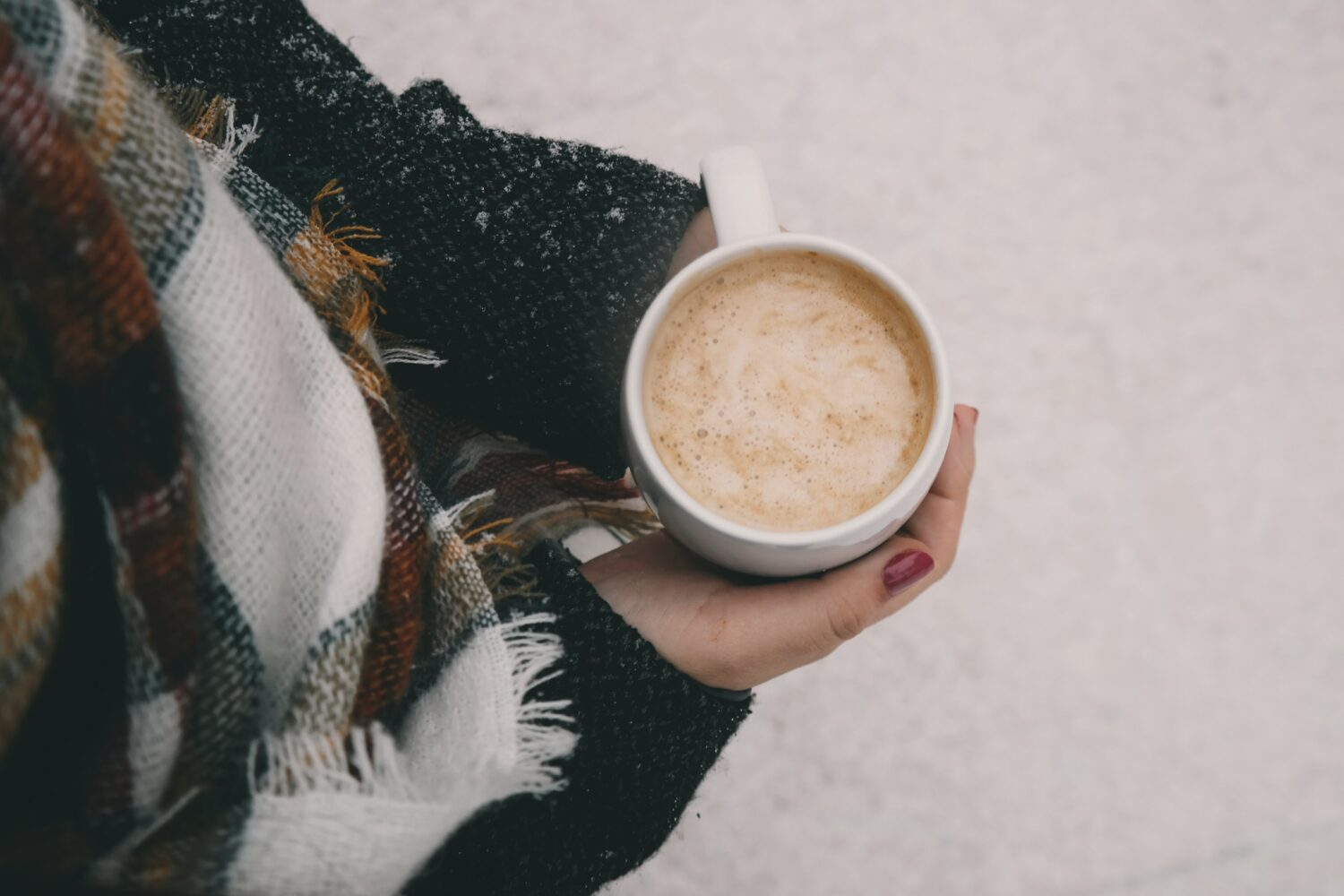 Person mit Kaffeetasse im Winter