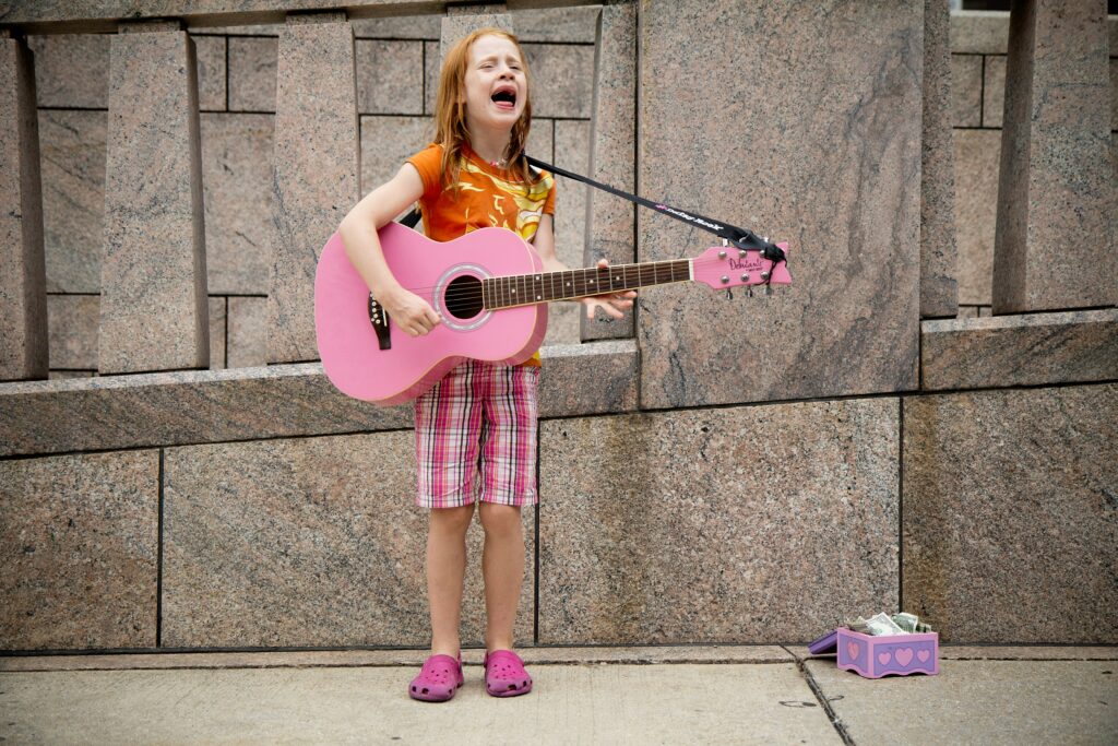 Mädchen singt lautstark mit pinker Gitarre. Symbolbild für Unternehmen, die sich Links verdienen müssen.